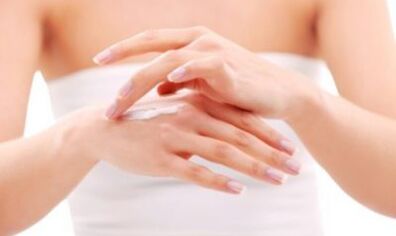 La fille applique une pommade sur sa main