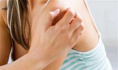 Une fille se gratte l'épaule